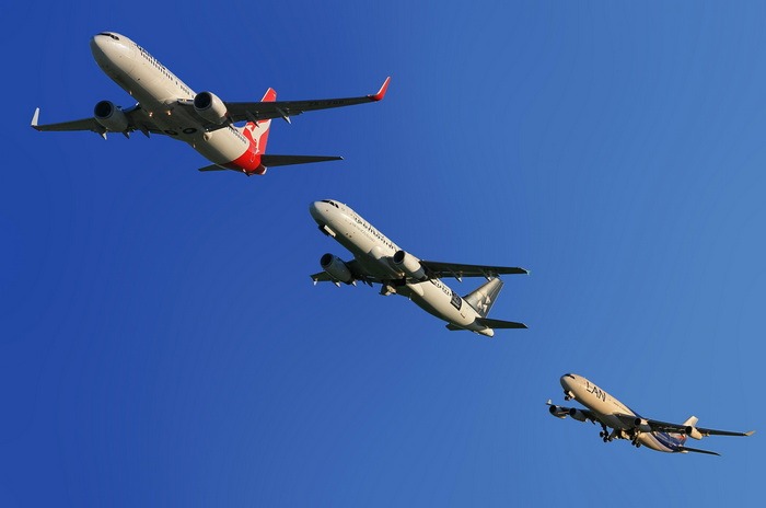 A picture of three passenger airplanes flying after each other