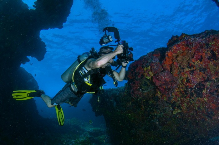 A picture of a diver taking pictures with an underwater camera